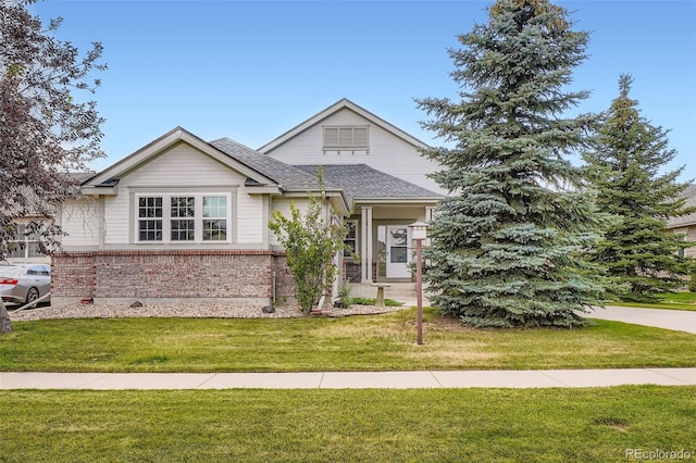 7831 S Addison Way, Aurora, CO 80016 - view of front facade featuring brick siding, a front yard, and roof with shingles