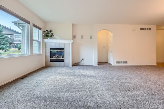 7831 S Addison Way, Aurora, CO 80016 - unfurnished living room featuring arched walkways, carpet, and a fireplace