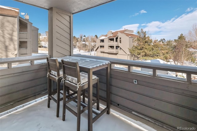 view of snow covered back of property