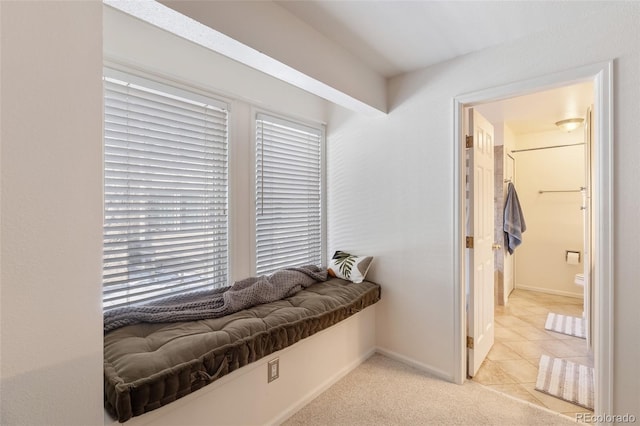 mudroom with light carpet, light tile patterned floors, and baseboards