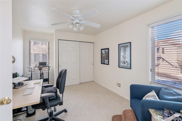 office area with a ceiling fan, carpet, and baseboards