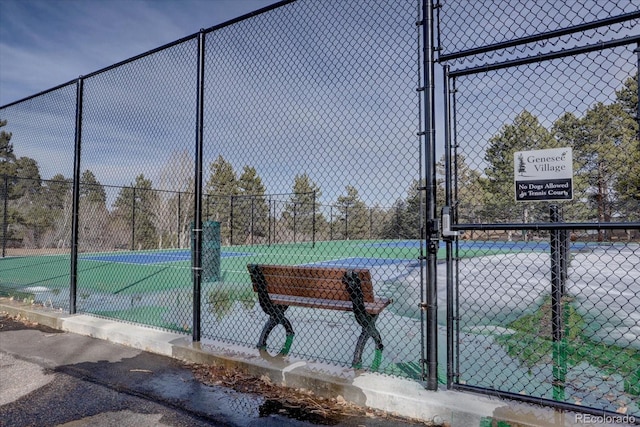 view of tennis court with fence and a gate