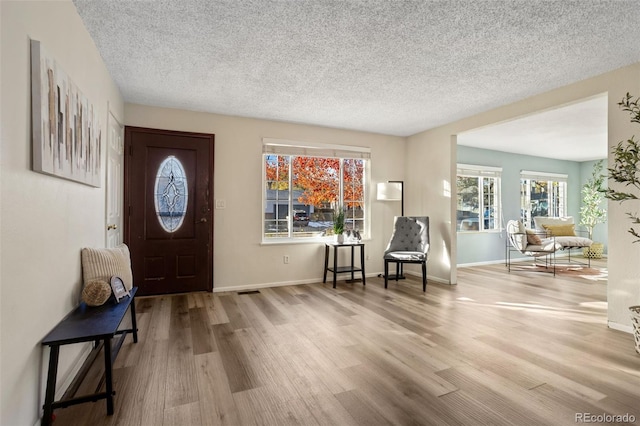 foyer entrance with wood-type flooring and a textured ceiling