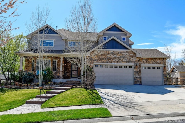 craftsman house featuring board and batten siding, stone siding, a front lawn, an attached garage, and concrete driveway