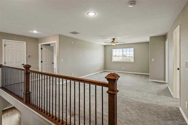 hall featuring carpet floors, baseboards, recessed lighting, and visible vents
