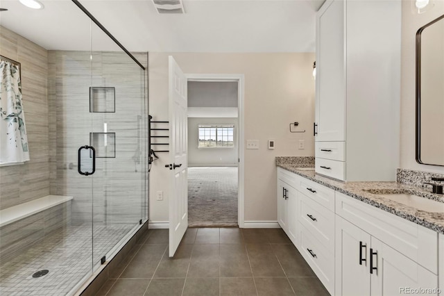 bathroom with a stall shower, visible vents, a sink, tile patterned floors, and double vanity