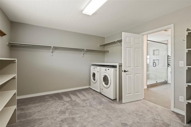 laundry area with carpet floors, baseboards, washing machine and dryer, and laundry area
