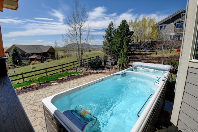view of swimming pool featuring fence, a lawn, and a hot tub