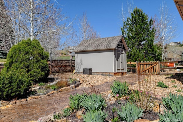 view of property exterior with an outdoor structure, fence, a shingled roof, and a storage unit