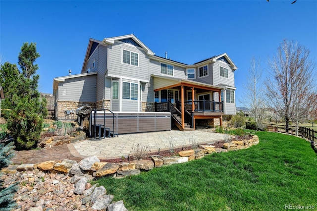 back of property featuring a patio area, fence, stone siding, and a yard