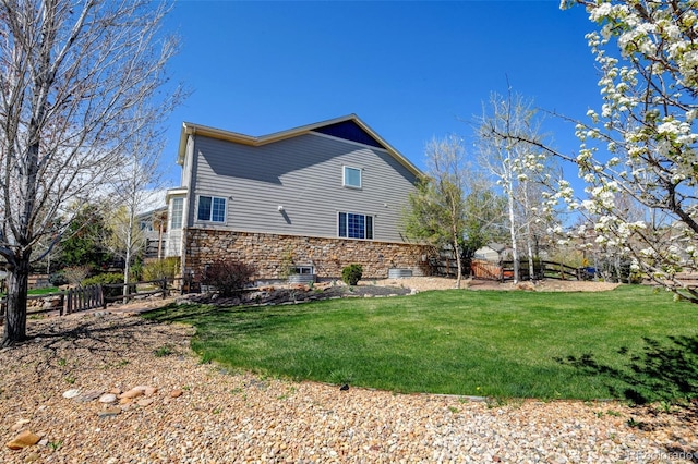 view of property exterior with fence and a lawn
