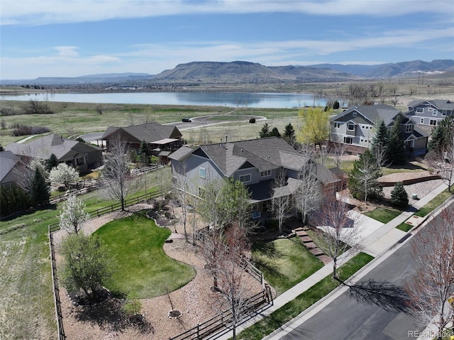 drone / aerial view with a water and mountain view and a residential view