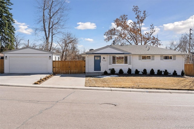 view of front of property featuring a garage, brick siding, fence, and a gate