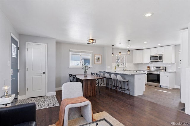 living area featuring recessed lighting, wood finished floors, and baseboards