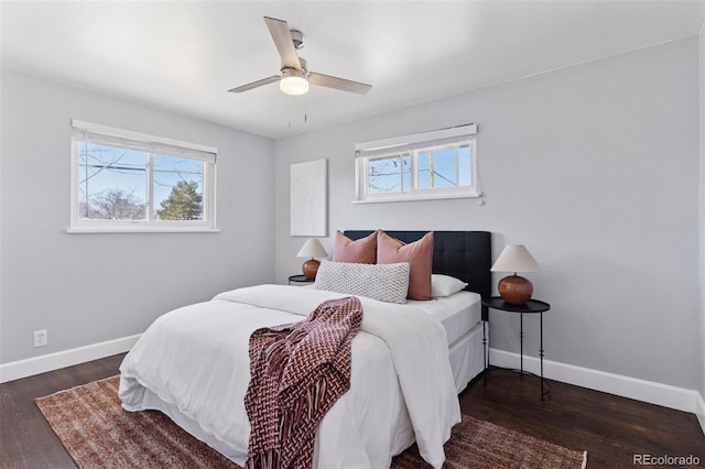 bedroom with multiple windows, wood finished floors, and baseboards