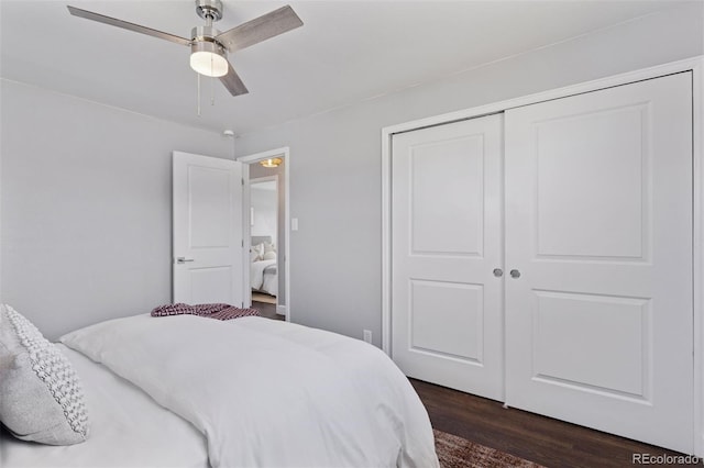 bedroom with dark wood-style floors, a closet, and a ceiling fan