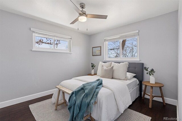 bedroom with multiple windows, dark wood finished floors, and baseboards