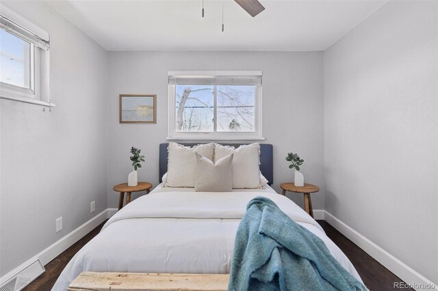 bedroom with multiple windows, visible vents, and dark wood finished floors