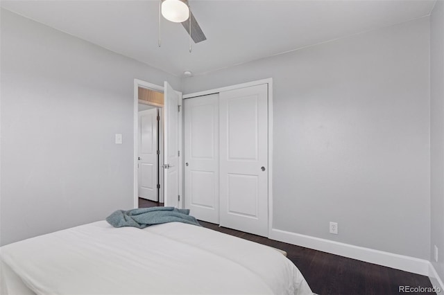 bedroom featuring a closet, dark wood finished floors, a ceiling fan, and baseboards