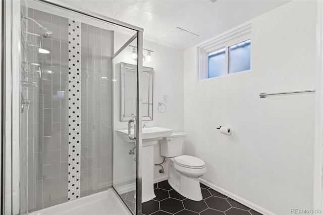 bathroom featuring a stall shower, tile patterned flooring, baseboards, and toilet