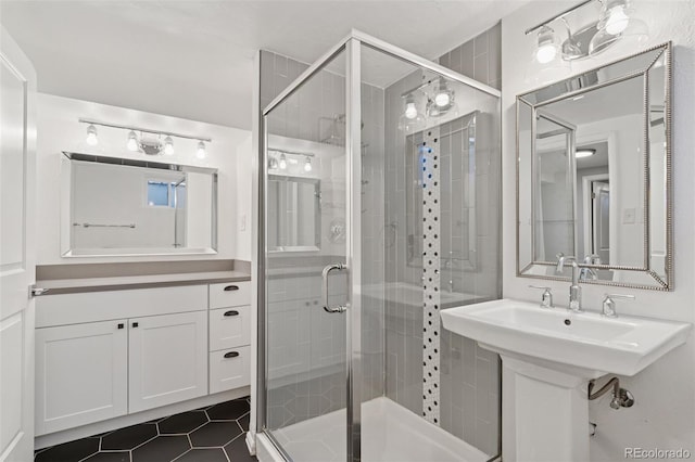 bathroom with a stall shower, tile patterned flooring, and a sink