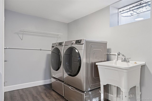 washroom with laundry area, baseboards, washer and dryer, and wood finished floors