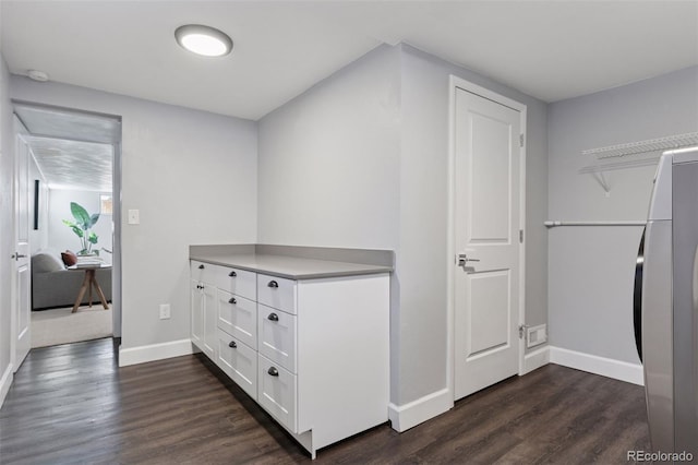 corridor with dark wood-style flooring and baseboards