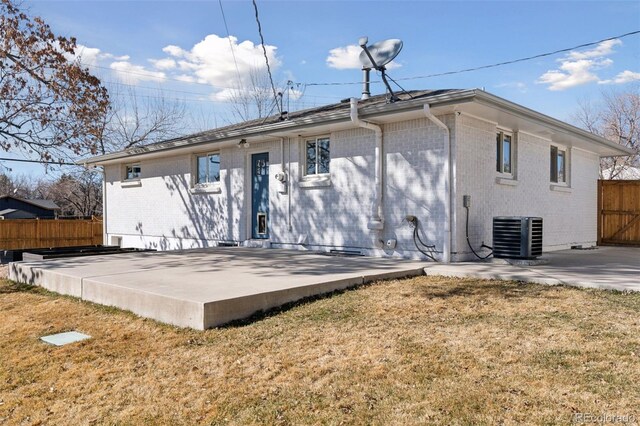 back of property with brick siding, fence, central AC, and a patio