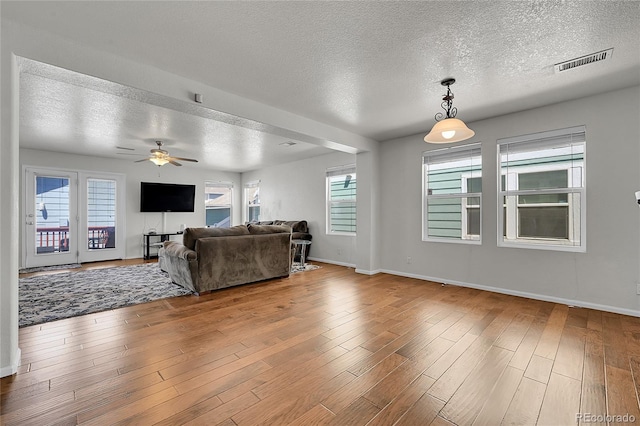 18947 E 57th Pl, Denver, CO 80249 - living room with a textured ceiling, plenty of natural light, ceiling fan, and wood finished floors