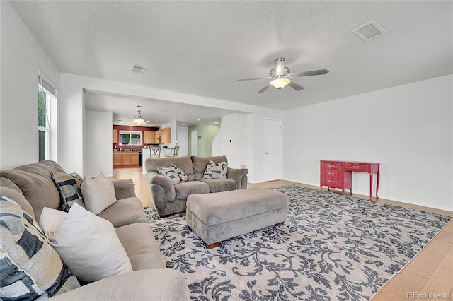18947 E 57th Pl, Denver, CO 80249 - living room featuring ceiling fan, light wood-type flooring, and a textured ceiling