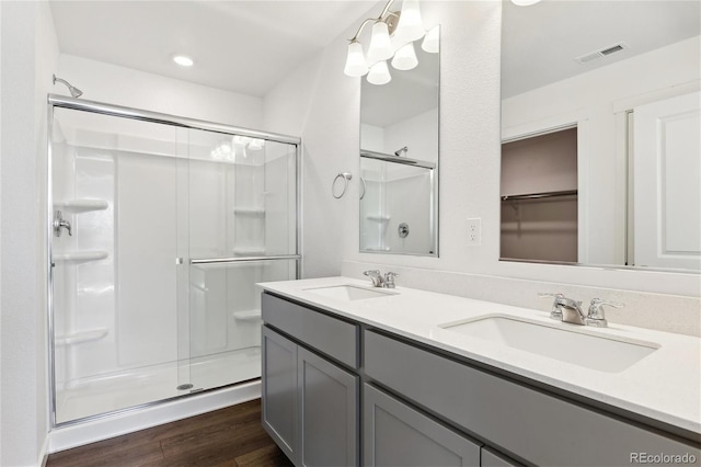 27424 E Byers Ave, Aurora, CO 80018 - bathroom with a shower stall, wood finished floors, double vanity, a chandelier, and recessed lighting