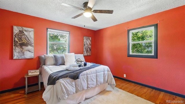 1930 S Prospect Ave, Colorado Springs, CO 80905 - bedroom with multiple windows, wood finished floors, a textured ceiling, baseboards, and a textured wall