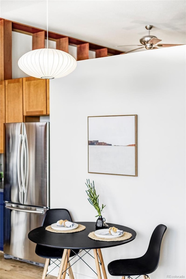 dining area with ceiling fan and wood-type flooring