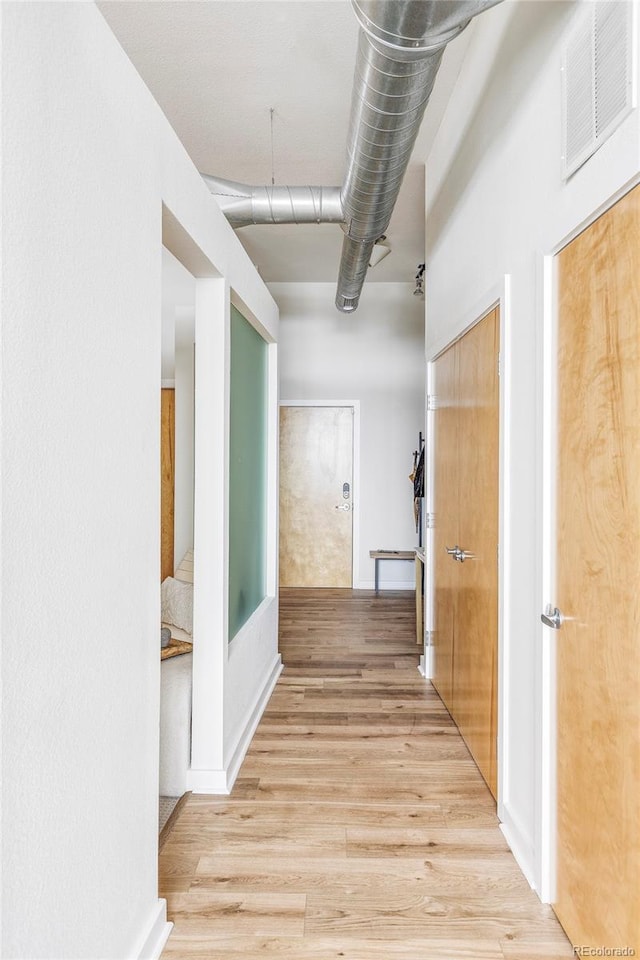 corridor with light wood-type flooring