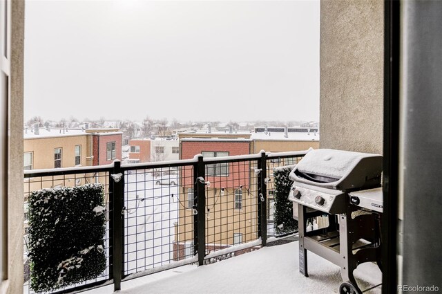 snow covered back of property featuring grilling area