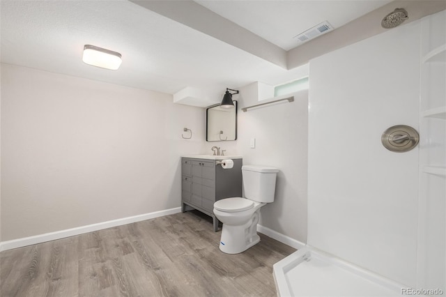 bathroom with walk in shower, vanity, wood-type flooring, and toilet