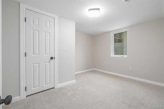 carpeted empty room featuring baseboards