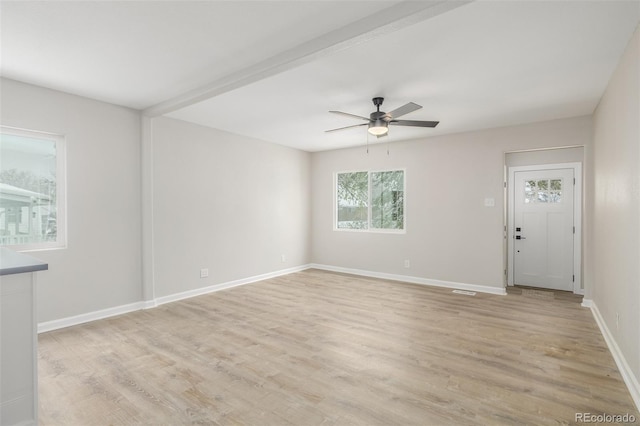 spare room with light wood-type flooring, baseboards, and a ceiling fan