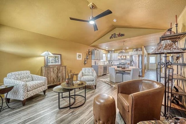 sitting room featuring hardwood / wood-style flooring, lofted ceiling, and ceiling fan