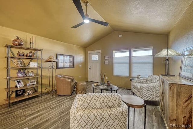 sitting room featuring ceiling fan, lofted ceiling, hardwood / wood-style floors, and a textured ceiling