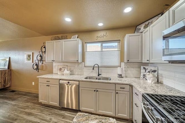 kitchen featuring sink, white cabinetry, light wood-type flooring, appliances with stainless steel finishes, and light stone countertops