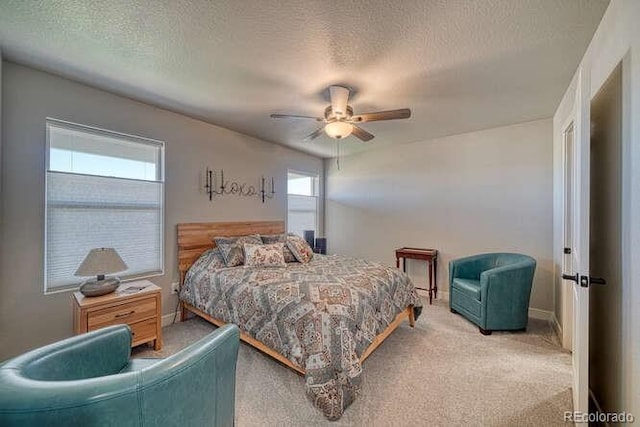 bedroom featuring ceiling fan, carpet, and a textured ceiling