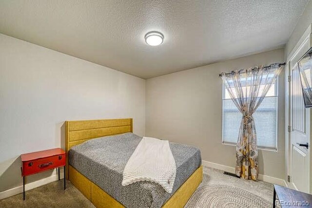 carpeted bedroom with a textured ceiling