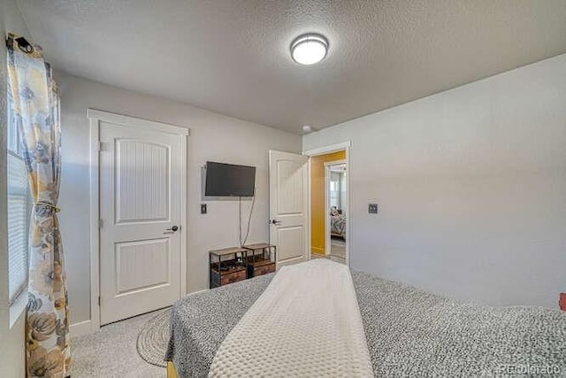 carpeted bedroom featuring a textured ceiling