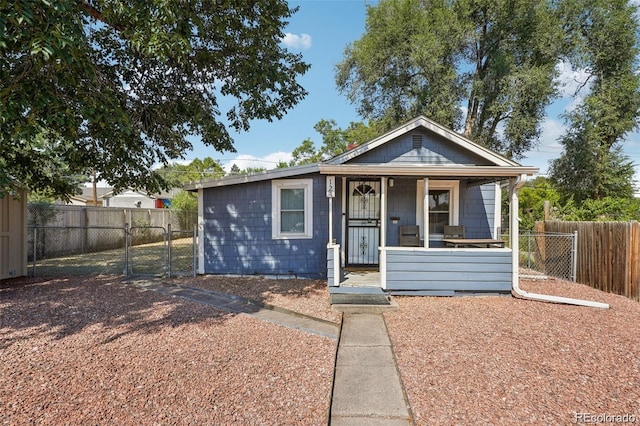 bungalow-style house featuring a porch, a gate, and fence