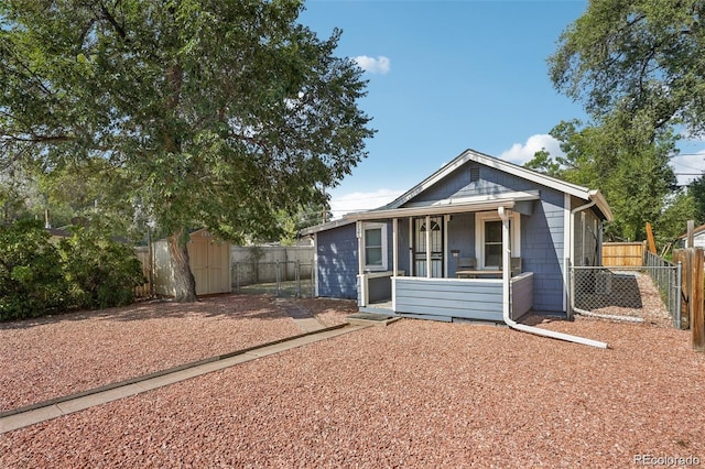 view of front of property with an outbuilding, a shed, covered porch, and fence