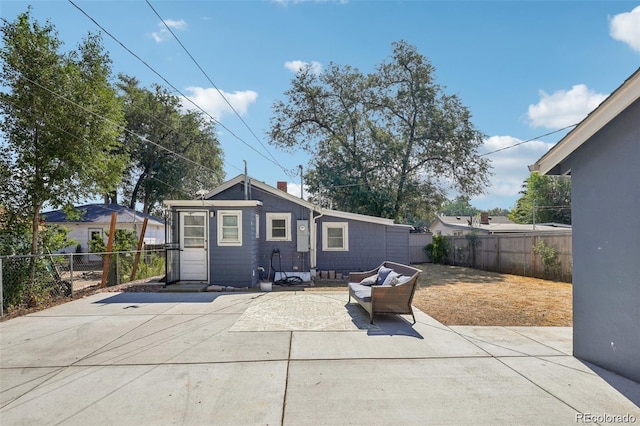 rear view of property with a chimney, a patio area, and a fenced backyard