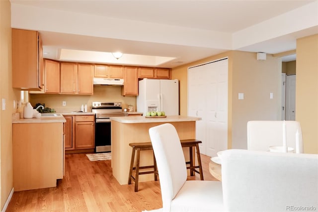 654 S Xenon Ct, Lakewood, CO 80228 - kitchen with stainless steel electric range oven, white refrigerator with ice dispenser, under cabinet range hood, a center island, and light countertops