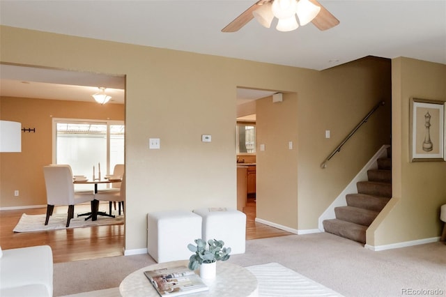 654 S Xenon Ct, Lakewood, CO 80228 - living area with stairs, ceiling fan, and light colored carpet
