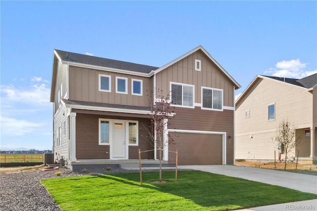 view of front facade with a garage, a front yard, and central AC